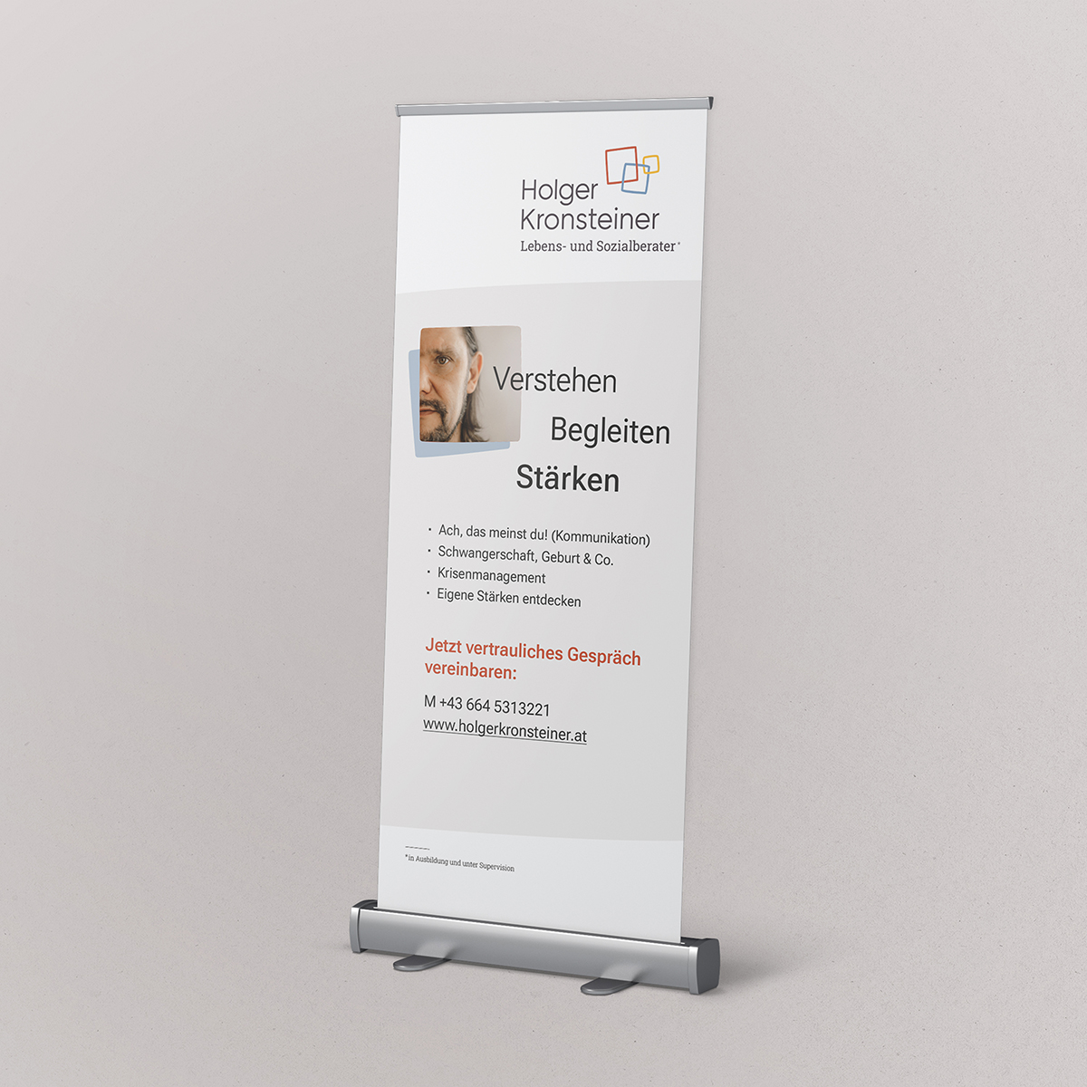 Bild von einem Rollup für Holger Kronsteiner, Lebens- und Sozialberater in Ausbildung und unter Supervision. Das Bild zeigt das Logo, ein Foto und die Worte "Verstehen, Begleiten, Stärken" sowie die Tätigkeitsbereiche und den Aufruf zur Terminvereinbarung für ein Gespräch. Copyright © 2025 Olivia Weise, Design & Illustration